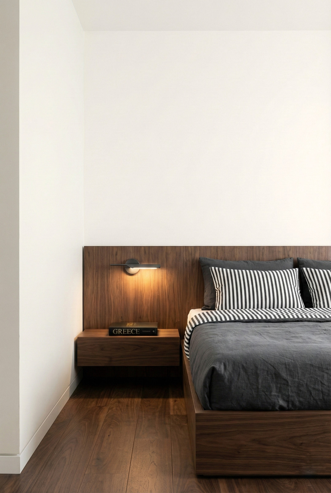 Μοντέρνο υπνοδωμάτιο με μινιμαλιστικές γραμμές, λευκούς τοίχους και ξύλινα στοιχεία.