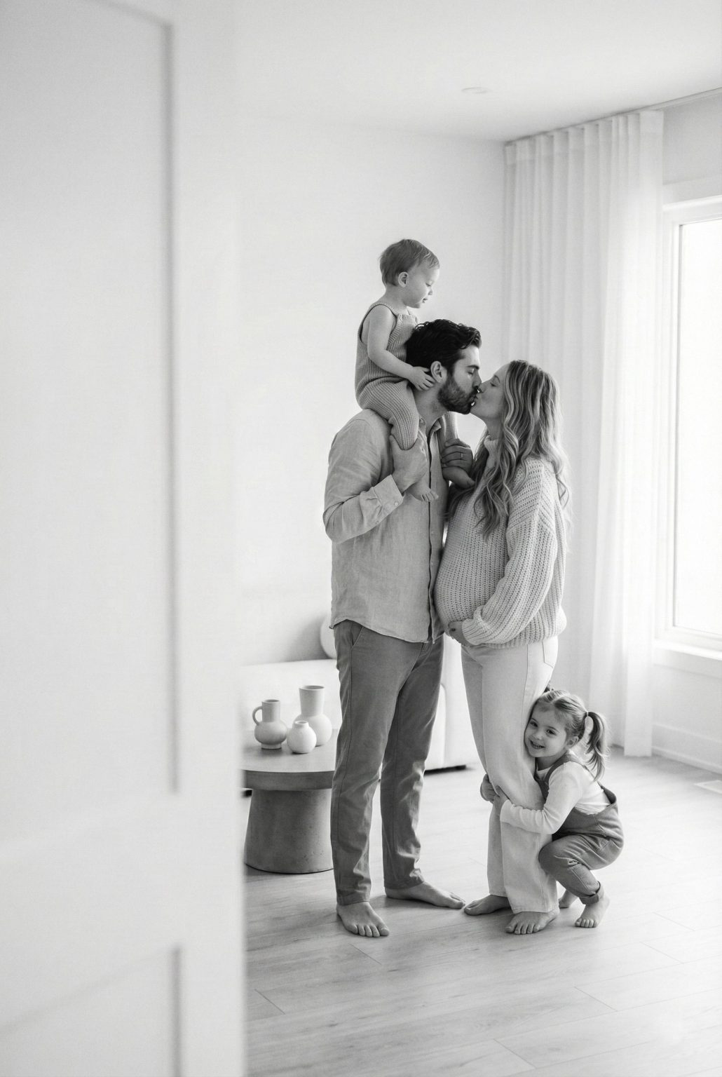 A family embraces and shares a kiss in the living room of their new home, expressing joy and emotion – U1 Boutique Realty Firm.